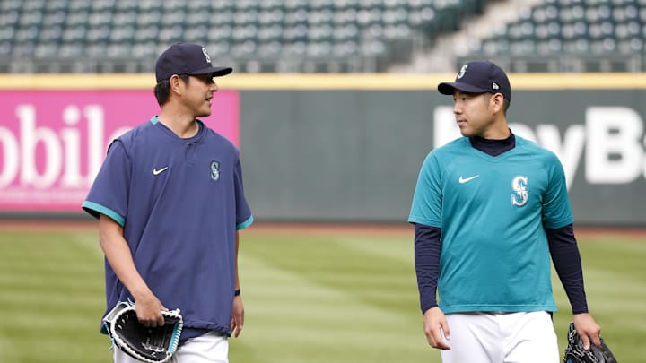 Seattle Mariners starting pitcher Yusei Kikuchi (18, right) and special assignment coach Hisashi Iwakuma, left, talk following batting practice before a game against the Boston Red Sox at T-Mobile Park in 2021.