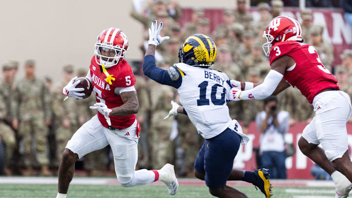 Nov 9, 2024; Bloomington, Indiana, USA; Indiana Hoosiers wide receiver Ke'Shawn Williams (5) runs with the ball while Michigan Wolverines defensive back Zeke Berry (10)  defends in the first quarter at Memorial Stadium. Mandatory Credit: Trevor Ruszkowski-Imagn Images
