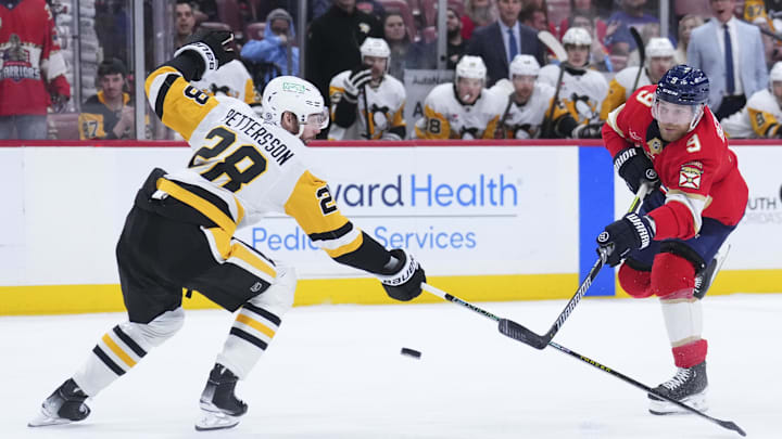Jan 3, 2025; Sunrise, Florida, USA; Florida Panthers center Sam Bennett (9) shoots the puck against  Pittsburgh Penguins defenseman Marcus Pettersson (28) during the first period at Amerant Bank Arena. Mandatory Credit: Rich Storry-Imagn Images