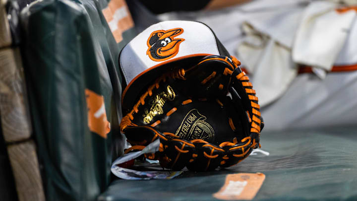 Jun 1, 2021; Baltimore, Maryland, USA; A Baltimore Orioles hat and glove are seen in the dugout during the fourth inning of the game between the Baltimore Orioles and the Minnesota Twins at Oriole Park at Camden Yards.