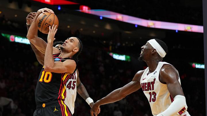 Apr 12, 2026; Miami, Florida, USA; Atlanta Hawks forward Zaccharie Risacher (10) battles for a rebound with Miami Heat guard Davion Mitchell (45) as center Bam Adebayo (13) looks on during the second half at Kaseya Center. Mandatory Credit: Jim Rassol-Imagn Images