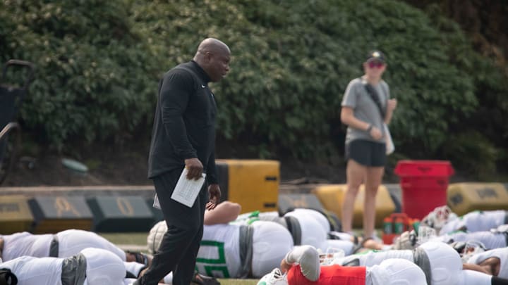 Oregon running backs coach Carlos Locklyn walks the field during practice with the Ducks Wednesday, Aug. 16, 2023.