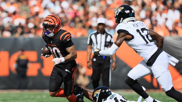 Oct 4, 2026; Cincinnati, Ohio, USA;  Cincinnati Bengals halfback Chase Brown (30) runs with the ball against Jacksonville Jaguars defensive end Travon Walker (44) during the first half at Paycor Stadium.  Mandatory Credit: Katie Stratman-Imagn Images