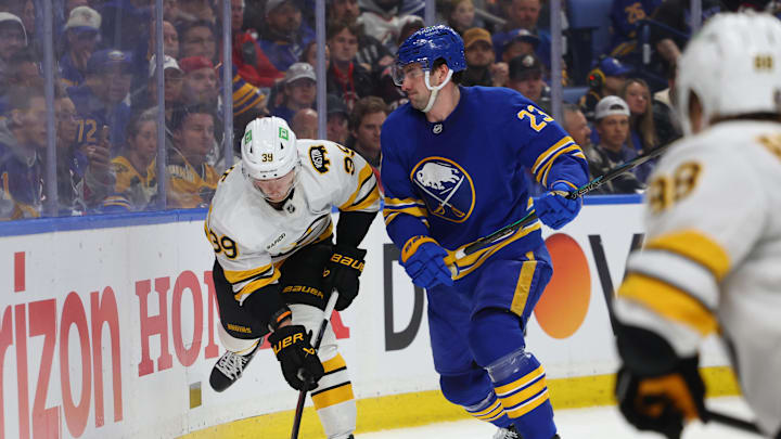 Apr 19, 2026; Buffalo, New York, USA; Buffalo Sabres defenseman Mattias Samuelsson (23) checks Boston Bruins center Morgan Geekie (39) as he tries to play the puck during the first period in game one of the first round of the 2026 Stanley Cup Playoffs at KeyBank Center. Mandatory Credit: Timothy T. Ludwig-Imagn Images