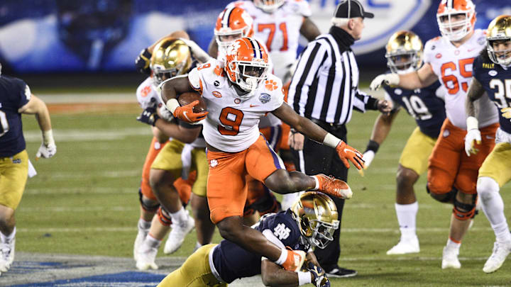 Dec 19, 2020; Charlotte, NC, USA; Clemson Tigers running back Travis Etienne (9) runs as Notre Dame Fighting Irish safety Shaun Crawford (20) defends in the third quarter at Bank of America Stadium. Mandatory Credit: Bob Donnan-USA TODAY Sports