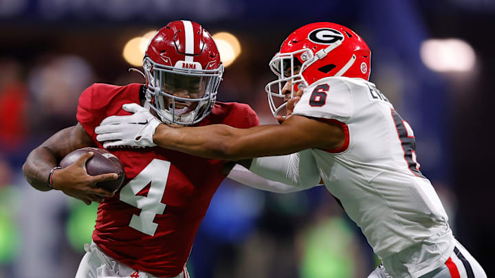 Jalen Milroe #4 of the Alabama Crimson Tide is pursued by Daylen Everette #6 of the Georgia Bulldogs during the first quarter in the SEC Championship at Mercedes-Benz Stadium on December 2, 2023 in Atlanta, Georgia.
