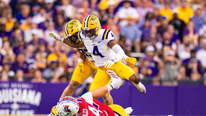 Sep 6, 2025; Baton Rouge, Louisiana, USA;  LSU Tigers cornerback Mansoor Delane (4) is stopped on a play against Louisiana Tech Bulldogs tight end Eli Finley (84) during the first half against Louisiana Tech Bulldogs at Tiger Stadium. Mandatory Credit: Stephen Lew-Imagn Images