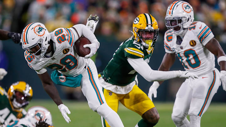Miami Dolphins running back De'Von Achane (28) loses his footing as he runs the ball against the Green Bay Packers on Thursday, November 28, 2024, at Lambeau Field in Green Bay, Wisconsin. Miami Dolphins running back De'Von Achane (28) loses his footing as he runs the ball against the Green Bay Packers on Thursday, November 28, 2024, at Lambeau Field in Green Bay, Wisconsin.
