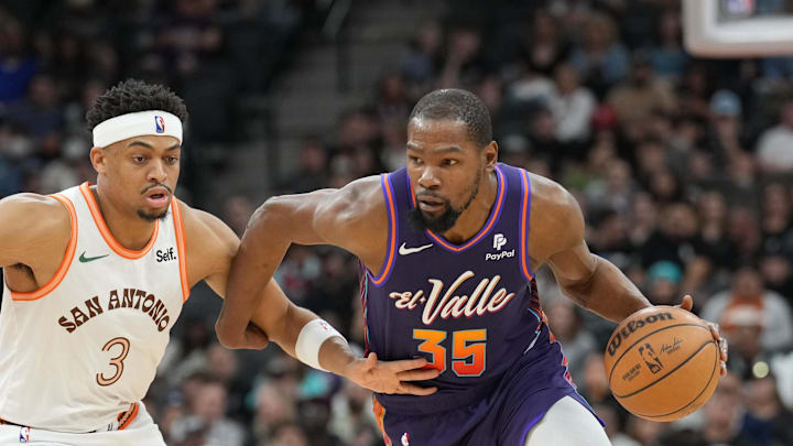 Mar 25, 2024; San Antonio, Texas, USA;  Phoenix Suns forward Kevin Durant (35) dribbles against San Antonio Spurs forward Keldon Johnson (3) in the second half at Frost Bank Center. Mandatory Credit: Daniel Dunn-Imagn Images