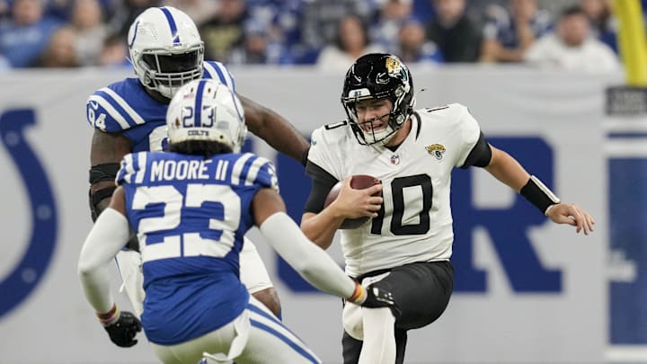 Jan 5, 2025; Indianapolis, Indiana, USA; Jacksonville Jaguars quarterback Mac Jones (10) slides as Indianapolis Colts cornerback Kenny Moore II (23) moves in to tackle during a game against the Jacksonville Jaguars  at Lucas Oil Stadium. Mandatory Credit: Christine Tannous/USA TODAY Network via Imagn Images
