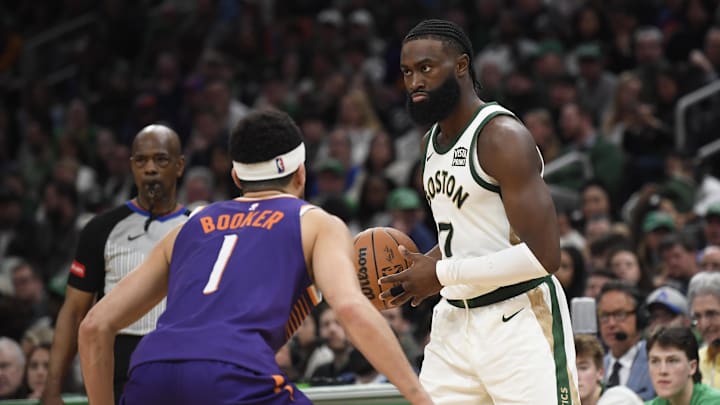 Mar 14, 2024; Boston, Massachusetts, USA;  Boston Celtics guard Jaylen Brown (7) controls the ball while Phoenix Suns guard Devin Booker (1) defends during the second half at TD Garden. Mandatory Credit: Bob DeChiara-Imagn Images
