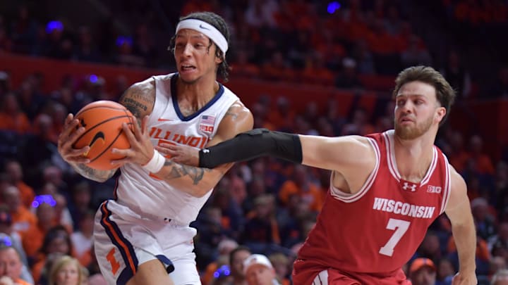 Dec 10, 2024; Champaign, Illinois, USA;  Wisconsin Badgers forward Carter Gilmore (7) reaches for the ball as Illinois Fighting Illini guard Tre White (22) pulls away a rebound during the first half at State Farm Center. Mandatory Credit: Ron Johnson-Imagn Images