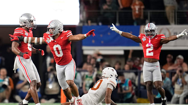 Ohio State Buckeyes linebacker Cody Simon (0) and safety Caleb Downs (2) celebrate a fourth down stop on a pass intended for Texas Longhorns wide receiver DeAndre Moore Jr. (0) during the first half of the Cotton Bowl Classic College Football Playoff semifinal game at AT&T Stadium in Arlington, Texas on Jan. 10, 2025.