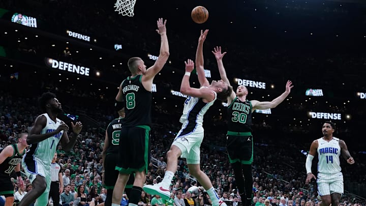 Apr 29, 2025; Boston, Massachusetts, USA; Boston Celtics center Kristaps Porzingis (8) and forward Sam Hauser (30) defend against Orlando Magic forward Franz Wagner (22) in the second quarter during game five of first round for the 2025 NBA Playoffs at TD Garden. Mandatory Credit: David Butler II-Imagn Images