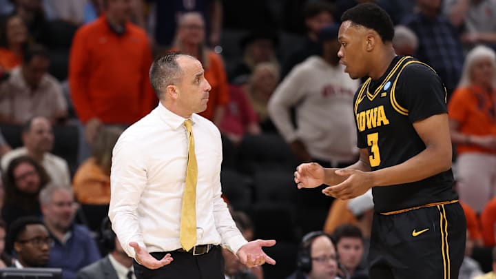 Iowa Hawkeyes head coach Ben McCollum talks with forward Cam Manyawu (3)