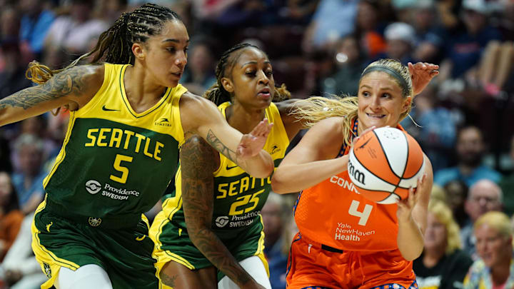 Jul 28, 2025; Uncasville, Connecticut, USA; Seattle Storm forward Gabby Williams (5) and guard Tiffany Mitchell (25) defend against Connecticut Sun guard Jacy Sheldon (4) in the second half at Mohegan Sun Arena. Mandatory Credit: David Butler II-Imagn Images