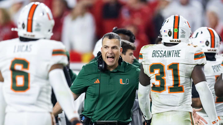Jan 19, 2026; Miami Gardens, FL, USA; Miami Hurricanes head coach Mario Cristobal with linebacker Wesley Bissainthe (31) against the Indiana Hoosiers during the College Football Playoff National Championship game at Hard Rock Stadium. Mandatory Credit: Mark J. Rebilas-Imagn Images Jan 19, 2026; Miami Gardens, FL, USA; Miami Hurricanes head coach Mario Cristobal with linebacker Wesley Bissainthe (31) against the Indiana Hoosiers during the College Football Playoff National Championship game at Hard Rock Stadium. Mandatory Credit: Mark J. Rebilas-Imagn Images