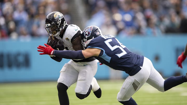 Jan 7, 2024; Nashville, Tennessee, USA;  Tennessee Titans linebacker Garrett Wallow (54) tackles Jacksonville Jaguars running back Travis Etienne Jr. (1) during the second half at Nissan Stadium. Mandatory Credit: Steve Roberts-Imagn Images