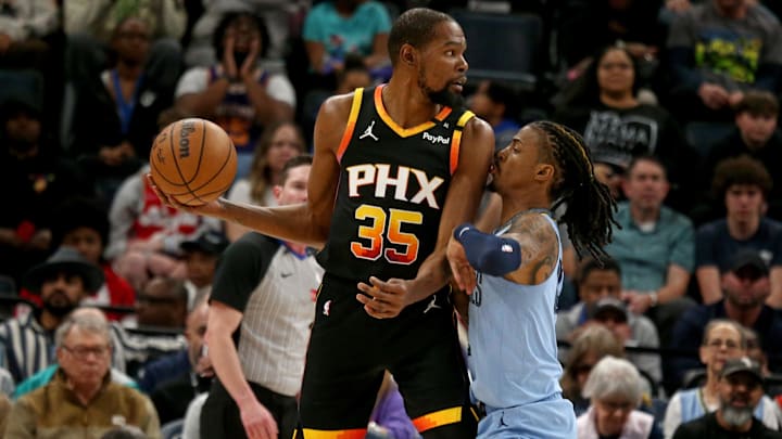 Phoenix Suns forward Kevin Durant (35) handles the ball as Memphis Grizzlies guard Ja Morant (12) defends during the first quarter at FedExForum in 2025.