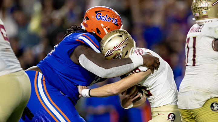 Florida Gators defensive lineman Desmond Watson (21) sacks Florida State Seminoles quarterback Tate Rodemaker (18) during the second half at Steve Spurrier Field at Ben Hill Griffin Stadium in Gainesville, FL on Saturday, November 25, 2023. [Matt Pendleton/Gainesville Sun]