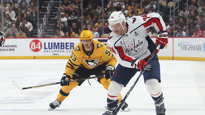 Nov 6, 2025; Pittsburgh, Pennsylvania, USA;  Washington Capitals defenseman John Carlson (74) moves the puck ahead of Pittsburgh Penguins right wing Philip Tomasino (53) during the second period at PPG Paints Arena. Mandatory Credit: Charles LeClaire-Imagn Images