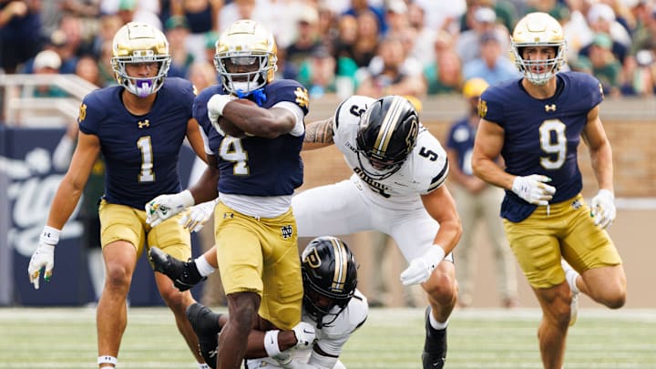 Purdue defensive back Smiley Bradford, bottom, tackles Notre Dame running back Jeremiyah Love (4) during the first half of a NCAA football game against Purdue at Notre Dame Stadium on Saturday, Sept. 20, 2025, in South Bend.