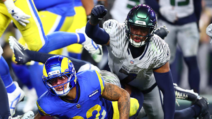 Dec 18, 2025; Seattle, Washington, USA; Los Angeles Rams running back Blake Corum (22) dives for a touchdown against Seattle Seahawks linebacker Uchenna Nwosu (7) in the second half at Lumen Field. Mandatory Credit: Kevin Ng-Imagn Images
