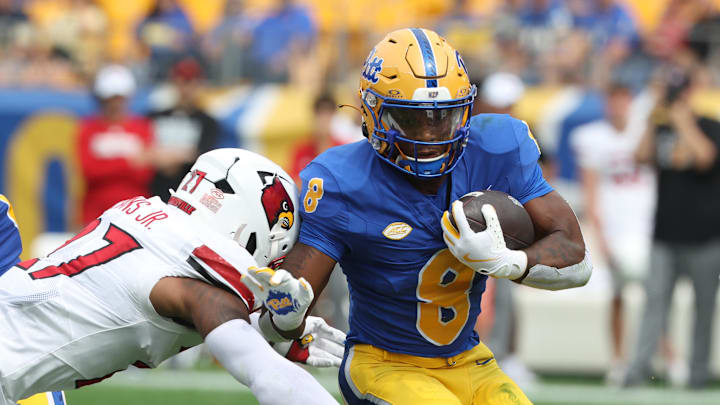 Sep 27, 2025; Pittsburgh, Pennsylvania, USA;  Pittsburgh Panthers running back Juelz Goff (8) runs the ball against Louisville Cardinals defensive back JoJo Evans Jr. (27) during the first quarter at Acrisure Stadium. Mandatory Credit: Charles LeClaire-Imagn Images