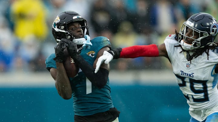 Dec 29, 2024; Jacksonville, Florida, USA; Jacksonville Jaguars wide receiver Brian Thomas Jr (7) catches the ball against Tennessee Titans cornerback Jarvis Brownlee Jr. (29) in the second quarter at EverBank Stadium. Mandatory Credit: Jeremy Reper-Imagn Images