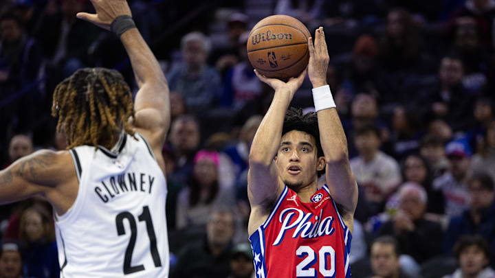 Nov 22, 2024; Philadelphia, Pennsylvania, USA; Philadelphia 76ers guard Jared McCain (20) shoots the ball past Brooklyn Nets forward Noah Clowney (21) during the fourth quarter at Wells Fargo Center. Mandatory Credit: Bill Streicher-Imagn Images
