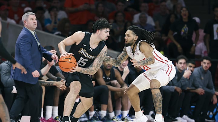 Nov 8, 2025; Houston, Texas, USA; Towson Tigers guard Tyler Tejada (15) controls the ball as Houston Cougars guard Emanuel Sharp (21) defends during the second half at Fertitta Center. Mandatory Credit: Troy Taormina-Imagn Images