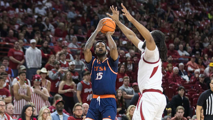Dec 7, 2024; Fayetteville, Arkansas, USA;  Texas-San Antonio Roadrunners forward Jonnivius Smith (15) shoots over Arkansas Razorbacks forward Jonas Aidoo (9) during the first half at Bud Walton Arena. Mandatory Credit: Brett Rojo-Imagn Images