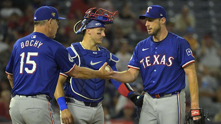 Jul 9, 2024; Anaheim, California, USA; Texas Rangers catcher Andrew Knizner (12) looks on as manager Bruce Bochy (15) pulls starting pitcher Max Scherzer (31) in the seventh inning against the Los Angeles Angels at Angel Stadium. Mandatory Credit: Jayne Kamin-Oncea-Imagn Images