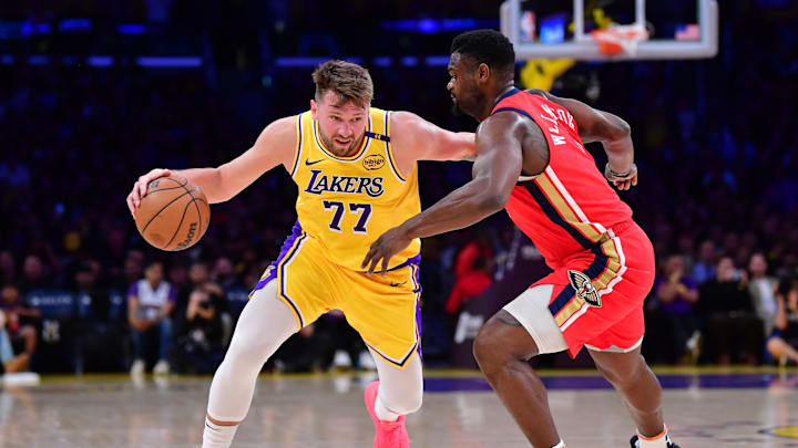 Mar 4, 2025; Los Angeles, California, USA;  Los Angeles Lakers guard Luka Doncic (77) moves the ball against New Orleans Pelicans forward Zion Williamson (1) during the first half at Crypto.com Arena. Mandatory Credit: Gary A. Vasquez-Imagn Images