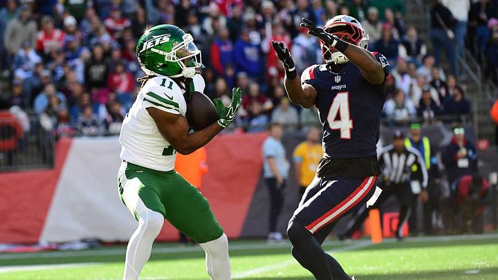 New York Jets wide receiver Omar Cooper Jr. (11) catches the ball past New England Patriots safety Craig Woodson (4) for a touchdown during the second half at Gillette Stadium.