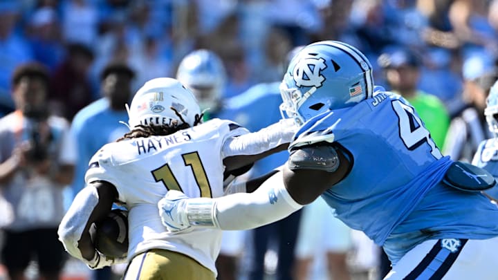 Oct 12, 2024; Chapel Hill, North Carolina, USA; Georgia Tech Yellow Jackets defensive lineman Kevin Harris II (11) with the ball as North Carolina Tar Heels defensive lineman Travis Shaw (4) defends in the third quarter at Kenan Memorial Stadium. Mandatory Credit: Bob Donnan-Imagn Images
