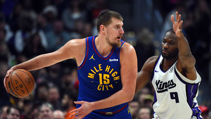 Nov 22, 2025; Denver, Colorado, USA; Denver Nuggets center Nikola Jokic (15) looks to pass the ball against Sacramento Kings forward Precious Achiuwa (9) during the second half at Ball Arena. Mandatory Credit: Christopher Hanewinckel-Imagn Images