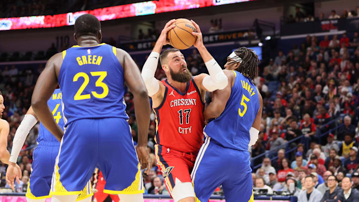 Oct 30, 2023; New Orleans, Louisiana, USA; New Orleans Pelicans center Jonas Valanciunas (17) tries to power past Golden State Warriors forward Kevon Looney (5) for a shot in the first quarter at Smoothie King Center. Mandatory Credit: Matthew Dobbins-Imagn Images