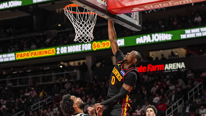 Feb 24, 2026; Atlanta, Georgia, USA; Atlanta Hawks forward Jonathan Kuminga (0)  scores over Washington Wizards forward Justin Champagnie (9) during the second half at State Farm Arena. Mandatory Credit: Dale Zanine-Imagn Images