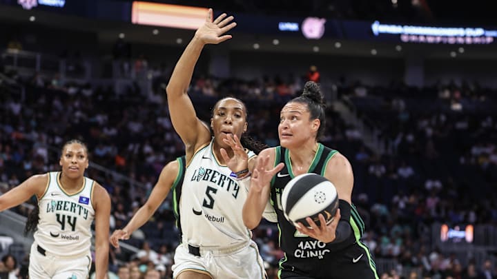 Kayla McBride of the Lynx dribbles past Kayla Thornton of the Liberty.