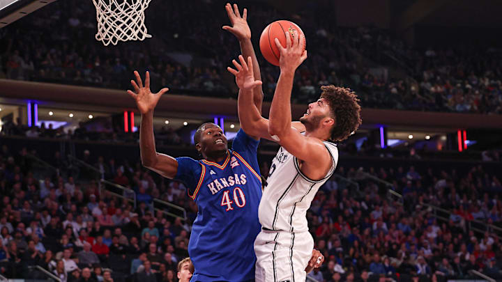 Nov 18, 2025; New York, New York, USA; Duke Blue Devils forward Cameron Boozer (12) shoots the ball as Kansas Jayhawks forward Flory Bidunga (40) defends during the second half at Madison Square Garden. Mandatory Credit: Vincent Carchietta-Imagn Images