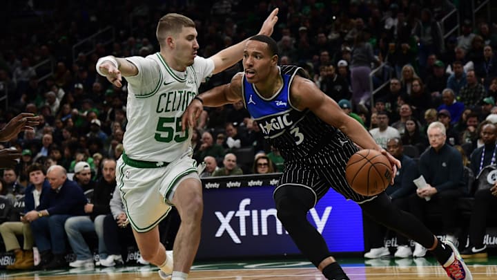 Nov 23, 2025; Boston, Massachusetts, USA; Orlando Magic guard Desmond Bane (3) controls the ball while Boston Celtics guard Baylor Scheierman (55) defends during the first half at TD Garden. Mandatory Credit: Bob DeChiara-Imagn Images