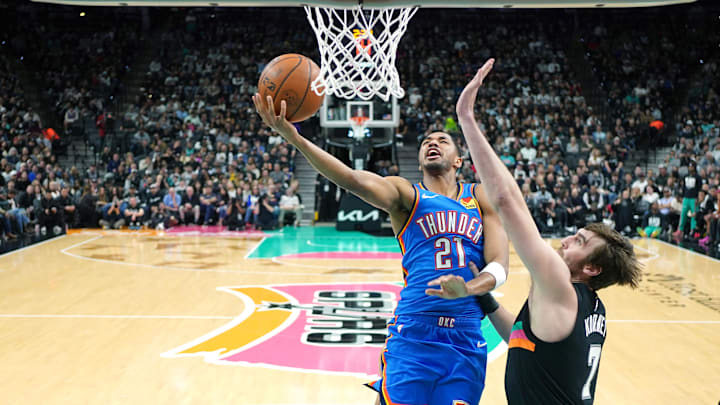 Feb 4, 2026; San Antonio, Texas, USA; Oklahoma City Thunder guard Aaron Wiggins (21) drives to the basket against San Antonio Spurs center Luke Kornet (7) during the first half at Frost Bank Center. Mandatory Credit: Scott Wachter-Imagn Images
