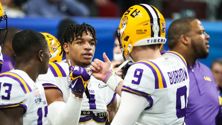 Dec 28, 2019; Atlanta, Georgia, USA; LSU Tigers wide receiver Ja'Marr Chase (1) greets quarterback Joe Burrow (9) before the 2019 Peach Bowl college football playoff semifinal game between the LSU Tigers and the Oklahoma Sooners at Mercedes-Benz Stadium. Mandatory Credit: Jason Getz-Imagn Images