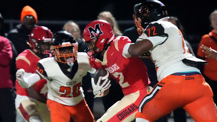 Cocoa High defenders O’Kece Battle (#20) and Chavez Thompson (#72) converge on Cardinal Mooney receiver Kymistrii Young (#2)