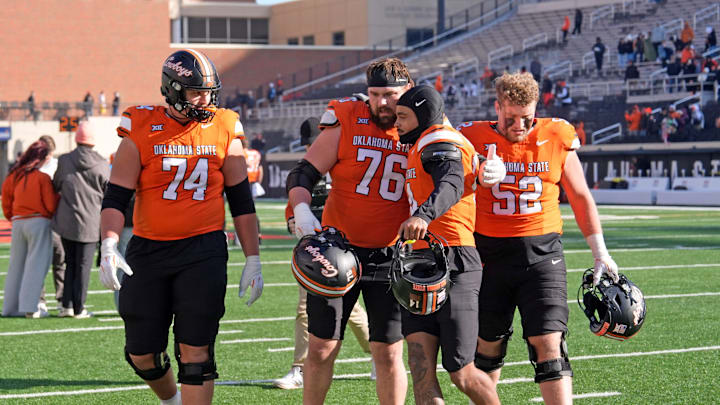 Oklahoma State's Grant Seagren (74), Bob Schick (76), Oklahoma State's Landyn Cleveland (14), and Kasen Carpenter (52) walk of the field following the college football game between the Oklahoma State Cowboys and the Iowa State Cyclones at Boone Pickens Stadium in Stillwater, Okla., Saturday Nov. 29, 2025.