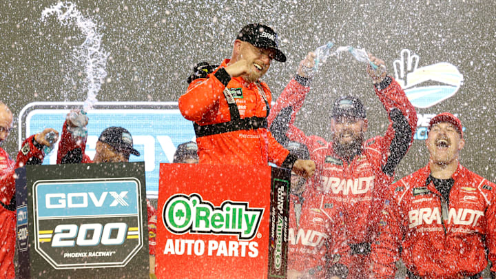 AVONDALE, ARIZONA - MARCH 07: Justin Allgaier, driver of the #7 BRANDT Chevrolet, and crew celebrate in victory lane after winning the NASCAR O'Reilly Auto Parts Series GOVX 200 at Phoenix Raceway on March 07, 2026, in Avondale, Arizona.