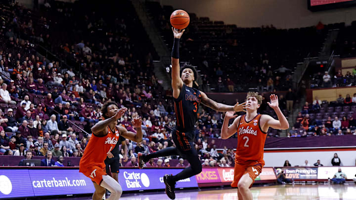 Jan 4, 2025; Blacksburg, Virginia, USA; Miami Hurricanes guard Jalil Bethea (3) shoots the ball against Virginia Tech Hokies guard Jaden Schutt (2) and forward Tobi Lawal (1) during the second half at Cassell Coliseum. Mandatory Credit: Peter Casey-Imagn Images