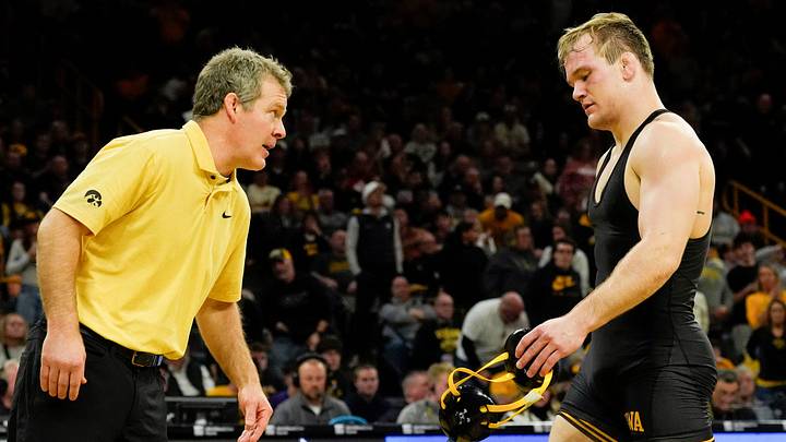 Iowa head coach Tom Brands talks to Iowa’s Nelson Brands as he walks off the mat after losing to Oklahoma State's Dean Hamiti Jr. Sunday, Feb. 23, 2025 at Carver-Hawkeye Arena in Iowa City, Iowa.