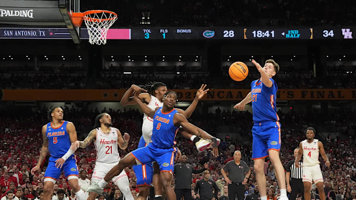 Florida Gators center Rueben Chinyelu (9) and Florida Gators forward Alex Condon (21) reach for a rebound against the Houston Cougars in the second half in the national championship game.